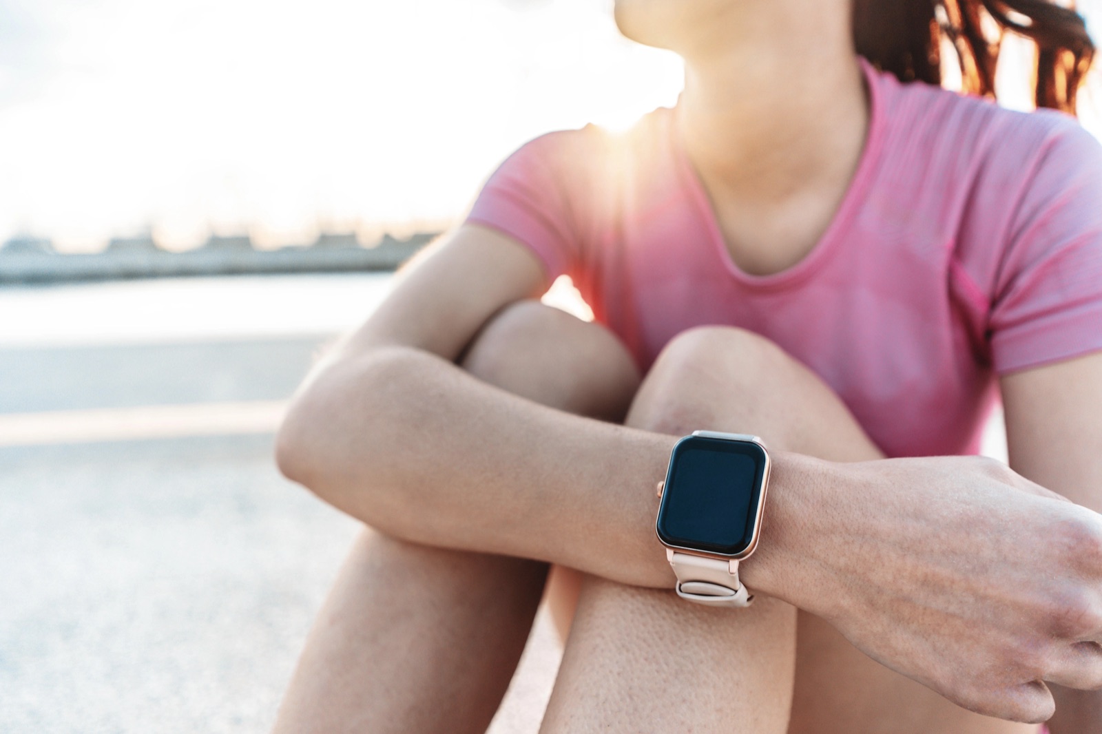 Sportive woman wearing smart watch during city workout